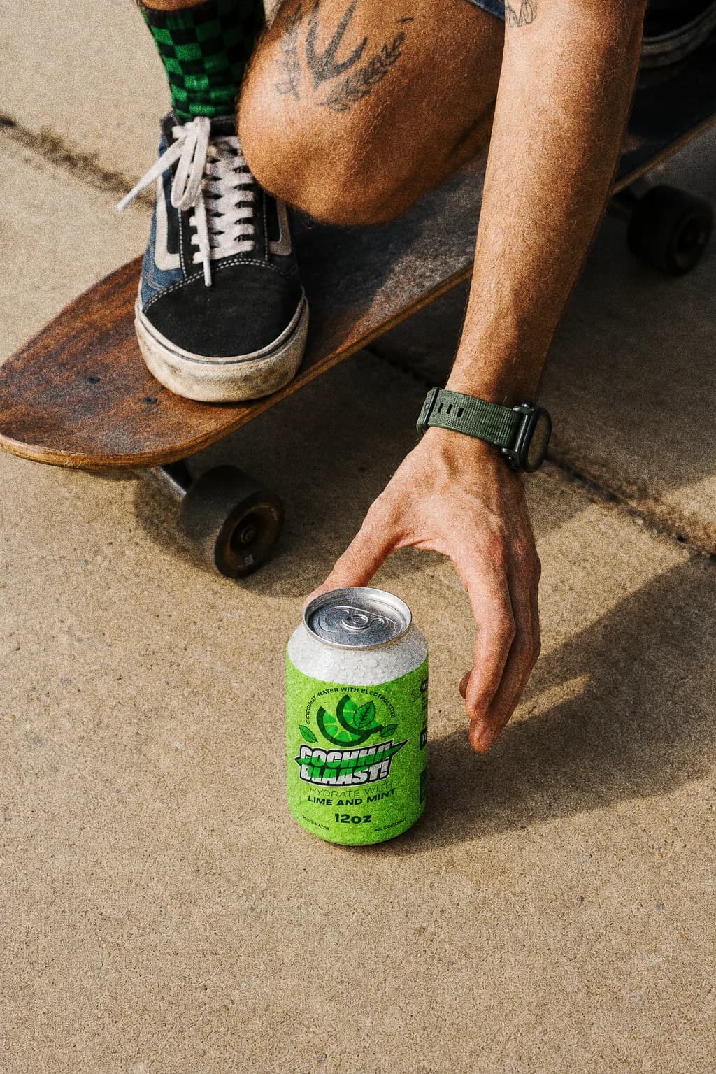 Cochaa Blaast lime and mint can on concrete beside a skateboard